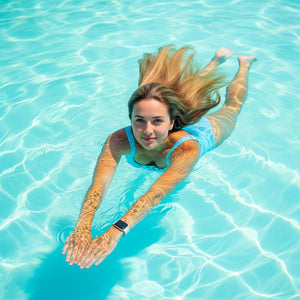 Woman swimming in clear blue water. Modbands Silicone Apple Watch band on wrist.